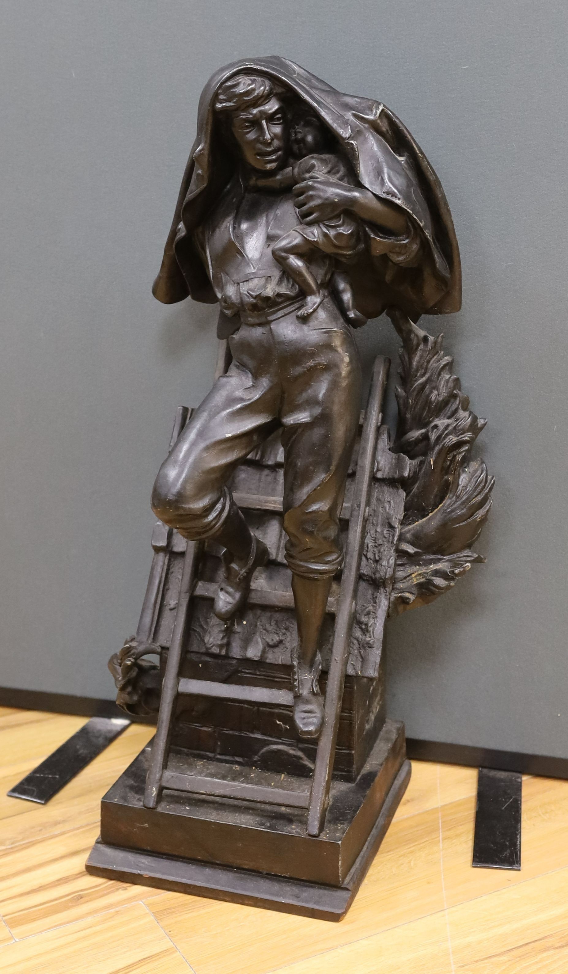 A cast spelter figure of a fireman performing rescue of a child, 81 cms high.